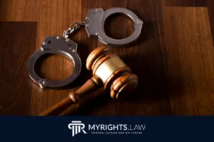 Un mazo de juez y un par de esposas descansan sobre una superficie de madera sobre el logotipo de MyRights.Law Theft Lawyer y DUI Attorney en Rancho Cucamonga.