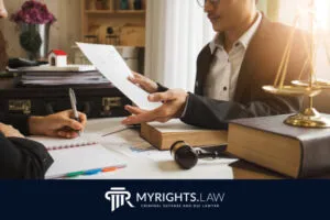 Two people discuss documents at a desk with legal books, a gavel, and scales of justice, next to a MYRIGHTS.LAW criminal defense and DUI lawyer logo, highlighting trusted Los Angeles Misdemeanor Lawyer services.
