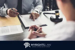 Two people sit at a desk with legal documents, one pointing at papers about DUI license reinstatement, a gavel nearby; 