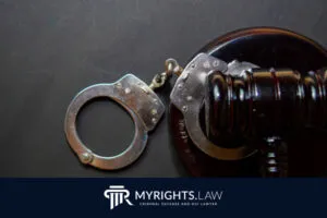 A pair of handcuffs rests on a judge's gavel, with the MyRights.Law logo and 