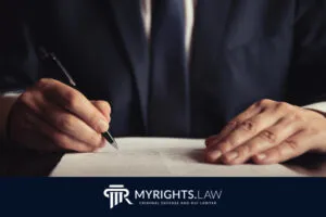 Una persona de traje firma un documento en un escritorio. La imagen muestra el logotipo de MYRIGHTS.LAW y el eslogan. 