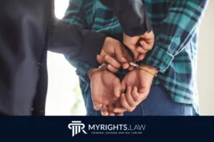 Una persona con camisa a cuadros es arrestada y esposada por un policía. El logotipo de MYRIGHTS.LAW, abogado de defensa penal y DUI, aparece en la parte inferior.