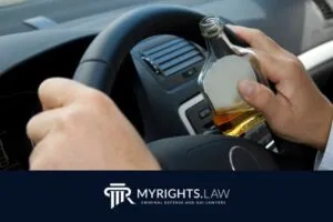 A person drives a car while holding a bottle of alcohol, with the MyRights.Law logo and tagline visible at the bottom, highlighting the importance of having a skilled Huntington Beach criminal defense attorney.