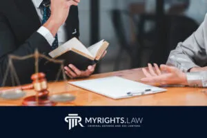Two people in business attire discuss legal documents at a desk with a scale, gavel, and book—symbolizing experienced Burbank criminal defense. 