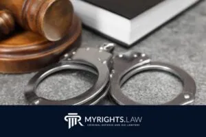 A pair of metal handcuffs, a judge's gavel, and a legal book on a gray surface highlight criminal defense, with the My Rights Law logo and tagline at the bottom—perfect for anyone seeking an attorney in Garden Grove.