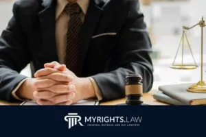 A person in a suit sits at a desk with a gavel and legal scales, representing a Torrance Criminal Defense attorney, with the MyRights.Law logo and slogan visible at the bottom.