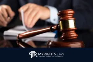 A judge’s gavel rests on a desk with a person in a suit—an attorney focused on their work—in the background; the text reads “MYRIGHTS.LAW Colton Criminal Defense and DUI Lawyers.”.