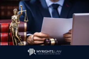 A Rialto attorney in a suit reviews documents at a desk with a gavel, law books, and Lady Justice statue; 