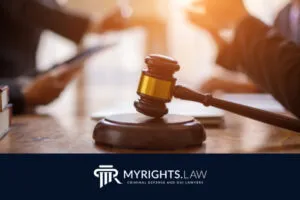 A judge’s gavel on a desk with blurred people in discussion in the background; MyRights.Law logo and tagline appear at the bottom, highlighting Highland Criminal Defense Attorney services.