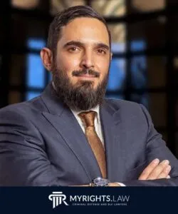 A man in a suit with a beard and mustache stands with arms crossed, representing a skilled Criminal Defense Attorney in Torrance. The MYRIGHTS.LAW logo is visible at the bottom of the image.