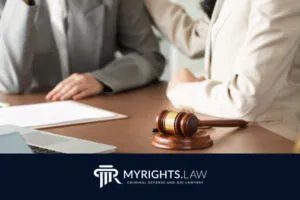 Two people in business attire sit at a desk with legal documents and a judge’s gavel, while the MYRIGHTS.LAW logo and tagline highlight the expertise of a Rancho Cucamonga CACI Removal Lawyer.