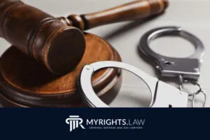 El mazo y las esposas de un juez descansan sobre un escritorio de madera, simbolizando la justicia. El logotipo del bufete. 