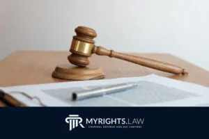 Un mazo de juez de madera reposa junto a un documento y un bolígrafo sobre un escritorio, simbolizando la justicia para quienes enfrentan delitos relacionados con el alcohol. El banner inferior muestra el logotipo de MyRights.Law y el texto. 