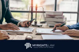 Two people in business suits review and sign legal documents at a desk with a gavel, scales, and law books, representing the expertise of a Rancho Cucamonga CACI Removal Lawyer. The My Rights Law logo and tagline are also featured.