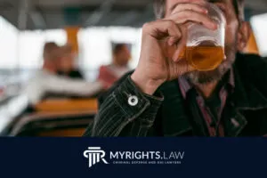 A person drinks from a plastic cup containing an amber liquid, with others seated in the background; at the bottom, a Rancho Cucamonga Bribery Lawyer firm's logo and name are displayed.